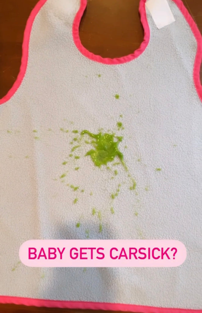 Oversized Car Seat Bib with green mess looks like vomit splattered on it. Text reads Baby Gets Carsick?