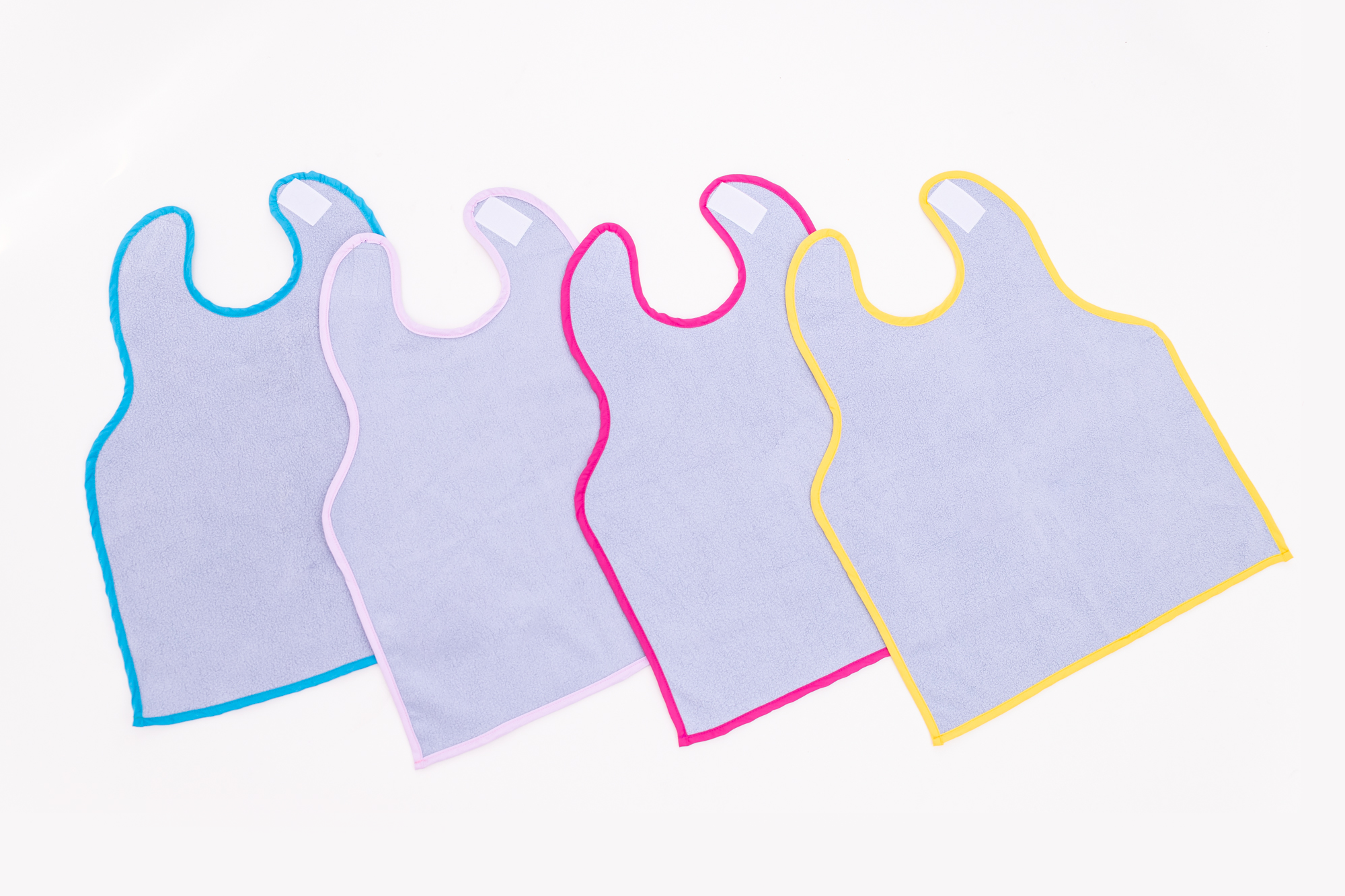 Oversized, ultra absorbent and waterproof bibs for the Car Seat or Feeding. In four colors: Blue, Lavender, Pink, and Yellow.
